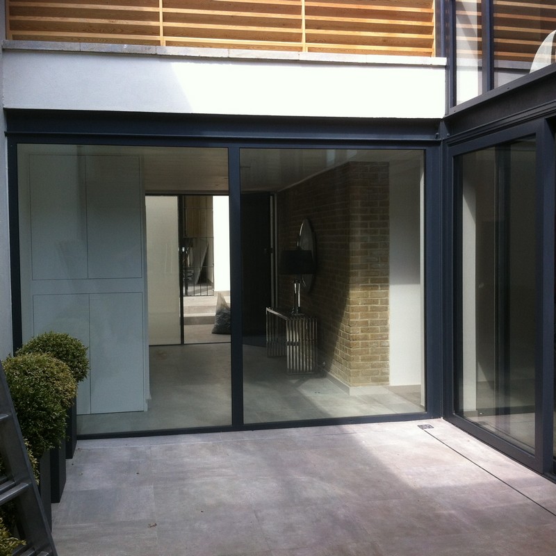 Floor-to-ceiling sliding doors opening to courtyard in Rickmansworth
